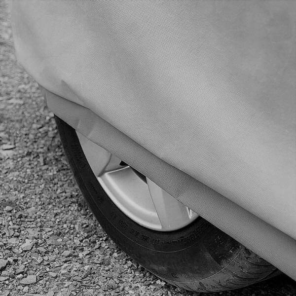 Detail of a car cover over a wheel, showcasing protection against weather elements and UV rays.