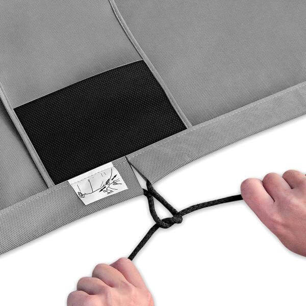 Detail of hands tightening the adjustable strap on a gray car cover with a breathable membrane.