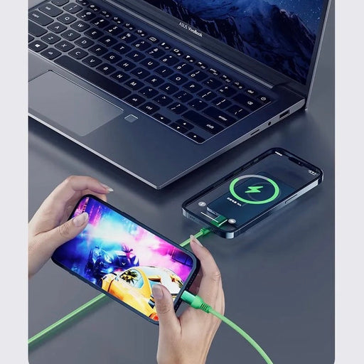 Powerbank Magsafe 10,000 mAh charging a phone wirelessly next to a laptop, highlighting portable and efficient energy solutions.