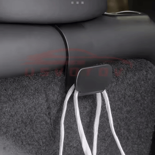 Schwarzer Kopfstützenhaken im Tesla Model Y, ideal für Einkaufstaschen und ordentliches Kofferraummanagement.
