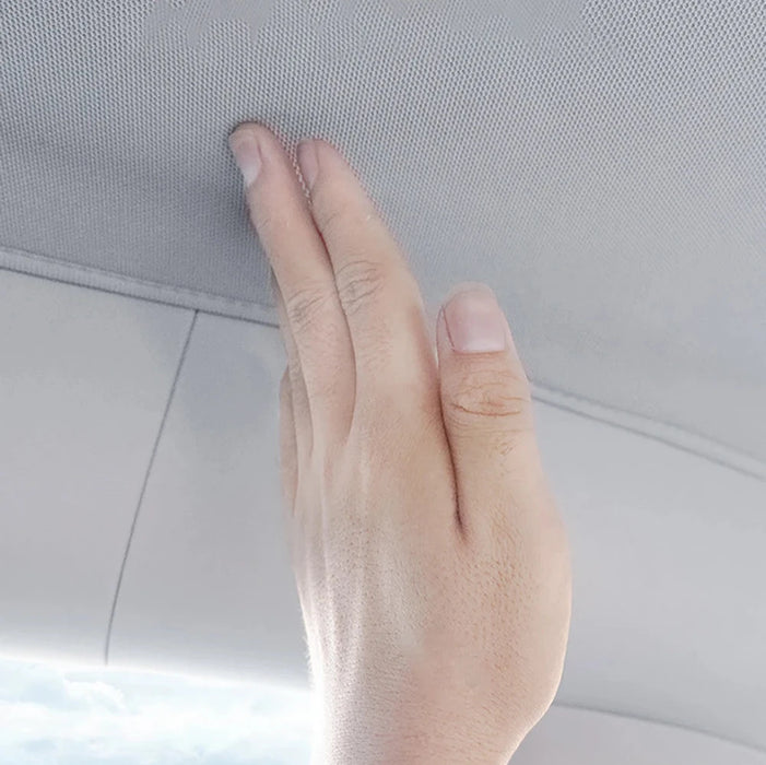 Hand touching the soft interior fabric of a Tesla Model Y, showcasing the premium material quality.